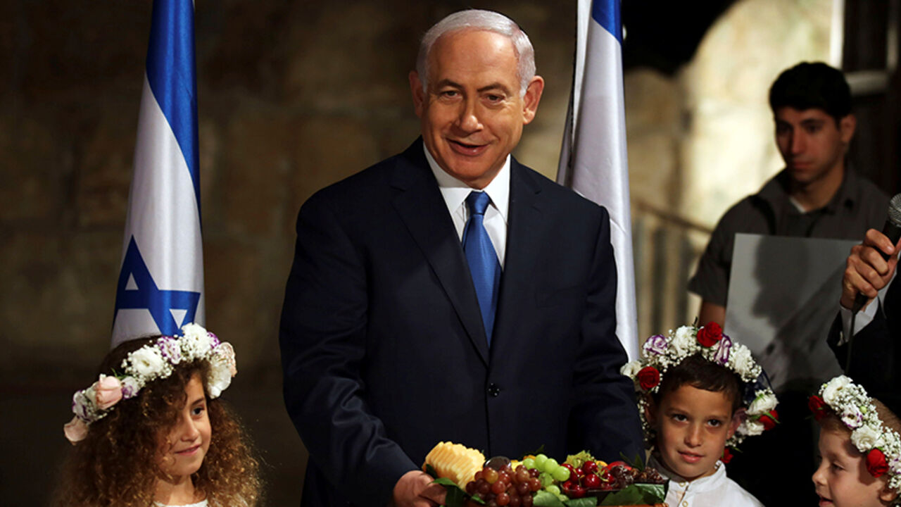 ISRAEL-POLITICS/ Israeli Prime Minister Benjamin Netanyahu holds a basket of fruit he received from local children, a custom associated with the upcoming Jewish holiday of Shavuot during a special cabinet meeting held in the Western Wall tunnels in Jerusalem's Old City May 28, 2017. REUTERS/Gali Tibbon/Pool - RTX37YH8