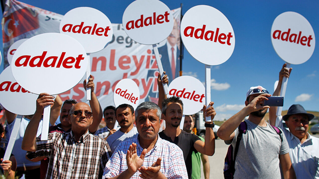 TURKEY-SECURITY/LAWMAKER Supporters of the main opposition Republican People's Party (CHP) hold placards as they walk with the party's leader Kemal Kilicdaroglu (not pictured) during the second day of a protest, dubbed a "justice march", against the detention of CHP lawmaker Enis Berberoglu, in Saray near Ankara, Turkey June 16, 2017. Placards read "Justice". REUTERS/Osman Orsal - RTS17CJ8