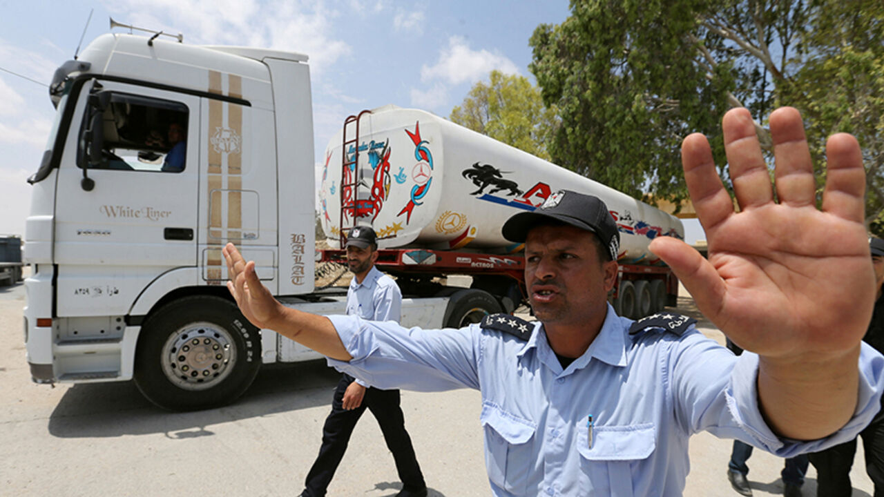 PALESTINIANS-EGYPT/GAZA Palestinian policemen loyal to Hamas stand guard as fuel tankers enter Gaza through the Rafah border between Egypt and southern Gaza Strip June 21, 2017. REUTERS/Ibraheem Abu Mustafa - RTS180DS