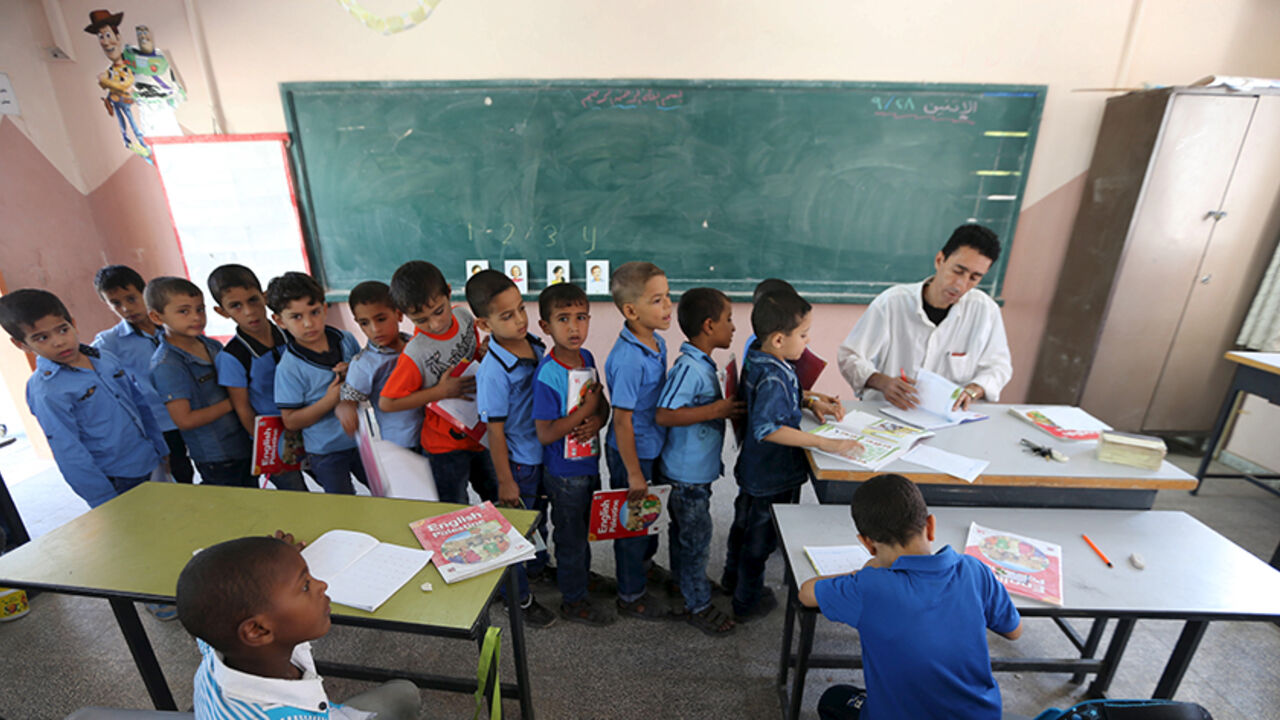 EDUCATION-GLOBAL/ Mohammed Zurob marks an exercise for his first grade students during an English lesson inside a classroom at Taha Huseen elementary school in Rafah in the southern Gaza Strip September 28, 2015. Nearly three years after Taliban gunmen shot Pakistani schoolgirl Malala Yousafzai, the teenage activist last week urged world leaders gathered in New York to help millions more children go to school. World Teachers' Day falls on 5 October, a Unesco initiative highlighting the work of educators struggling to teach c