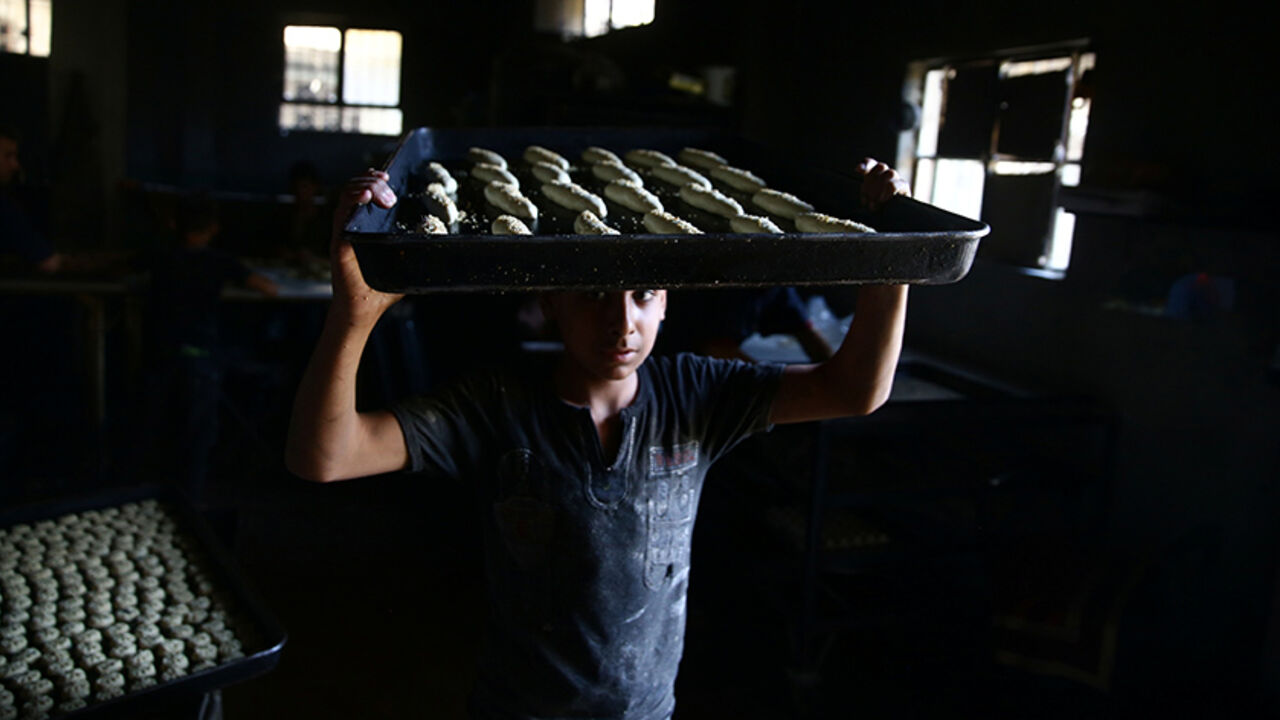 RELIGION-RAMADAN/SYRIA A boy carries raw pastries prior to baking, to be sold during Ramadan in the rebel held besieged eastern Damascus suburb of Ghouta, Syria May 28, 2017. REUTERS/Bassam Khabieh - RTX380FD