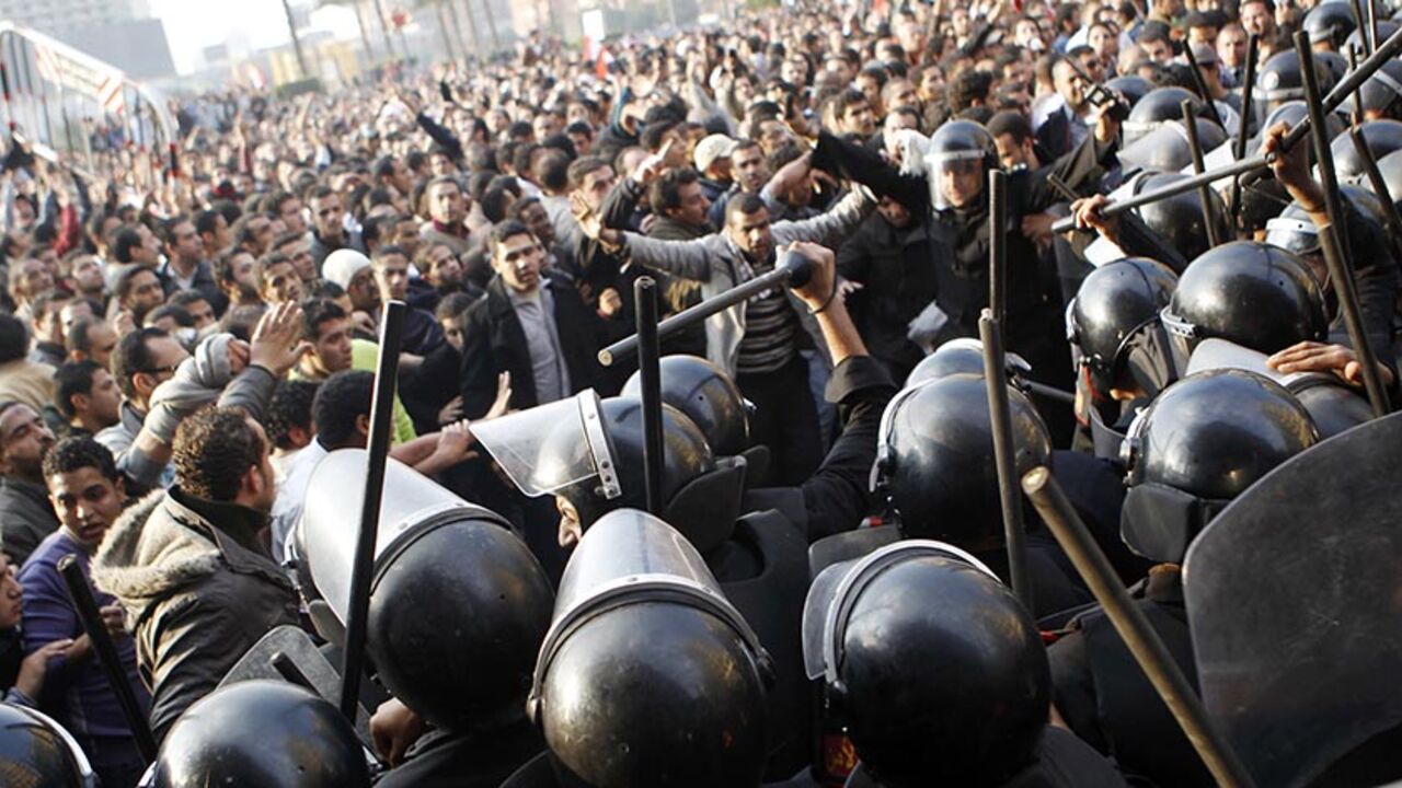 EGYPT-PROTEST/ Anti-government protesters demonstrate near riot police at Tahrir Square in downtown Cairo January 25, 2011. Thousands of Egyptians demanded an end to President Hosni Mubarak's 30-year rule and clashed with police on Tuesday, in unprecedented protests inspired by the revolt that brought down Tunisia's president. REUTERS/Amr Abdallah Dalsh (EGYPT - Tags: CIVIL UNREST POLITICS) - RTXX2LD