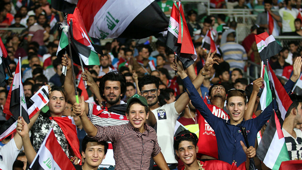 AFP_P66K9 Supporters of the Iraqi national team wave their national flag during the international friendly football match between Iraq and Jordan at Basra Sports City in Basra on June 1, 2017. / AFP PHOTO / HAIDAR MOHAMMED ALI (Photo credit should read HAIDAR MOHAMMED ALI/AFP/Getty Images)