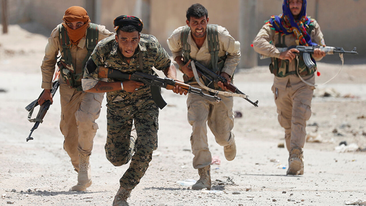Kurdish fighters from the People's Protection Units (YPG) run across a street in Raqqa, Syria July 3, 2017. REUTERS/Goran Tomasevic     TPX IMAGES OF THE DAY - RTS19M60
