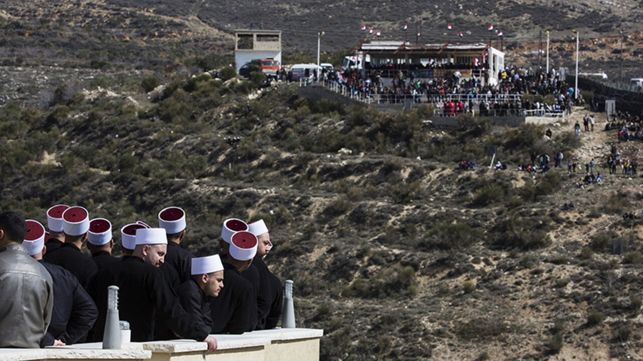 ISRAEL/ Members of the Druze community look at their friends and relatives (R) on the Syrian side of the border, during a rally in the Druze village of Majdal Shams on the Golan Heights, which stands at the heart of a long-standing conflict between Israel and Syria, February 14, 2014. Hundreds of members of the Druze community took part in the rally on Friday, marking the 33rd anniversary of Israel's annexation of the strategic plateau which it captured in the 1967 Middle East War. REUTERS/Baz Ratner (POLITICS ANNI