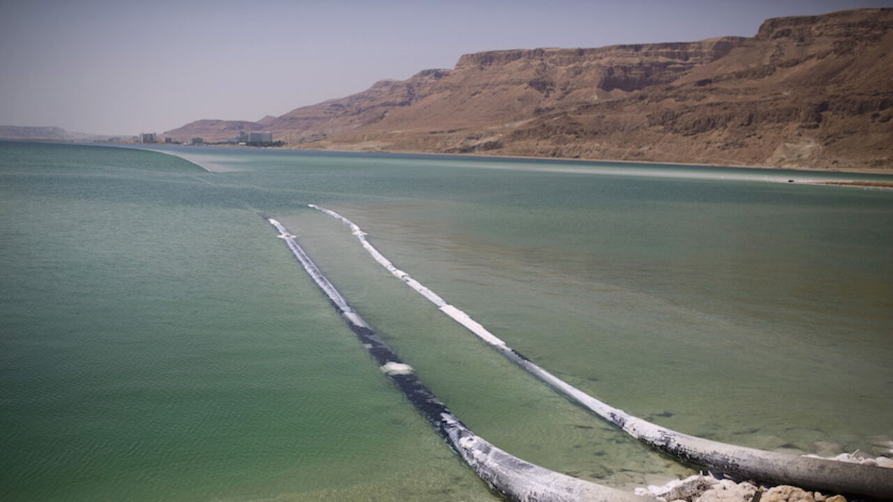 Pipes that pump water cross through evaporation pools, which today make up the southern part of the Dead Sea, Israel July 27, 2015. The Dead Sea is shrinking, and as its waters vanish at a rate of more than one meter a year, hundreds of sinkholes, some the size of a basketball court, some two storeys deep, are devouring land where the shoreline once stood.Picture taken July 27, 2015. REUTERS/Amir Cohen - RTX1M941