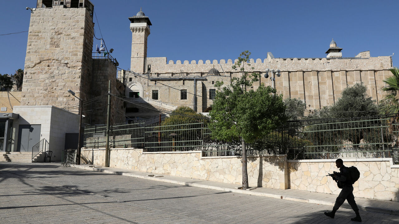 ISRAEL-PALESTINIANS/HEBRON An Israeli soldier walks past Ibrahimi Mosque, which Jews call the Jewish Tomb of the Patriarchs, in the West Bank city of Hebron July 7, 2017. REUTERS/Ammar Awad - RTX3AJ9Z