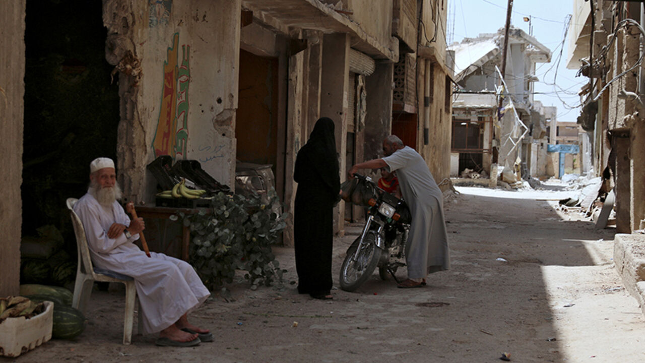 MIDEAST-CRISIS/SYRIA-SOUTH An elderly man sits in front of a vegetable shop near damaged buildings in the province of Daraa, Syria July 11, 2017. REUTERS/ Alaa al-Faqir - RTX3AZSY