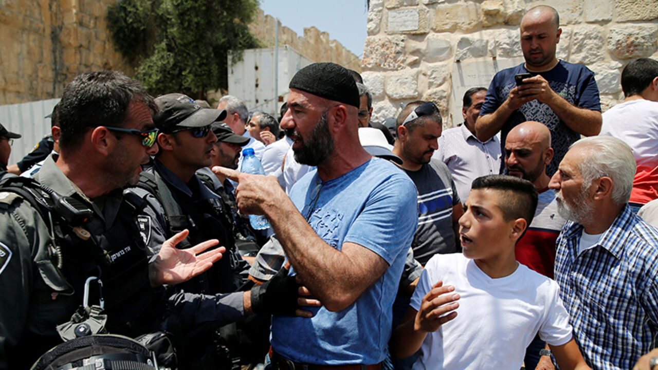 ISRAEL-PALESTINIANS/ A Palestinian argues with an Israeli border police officer during scuffles that erupted after Palestinians held prayers just outside Jerusalem's Old City in protest over the installation of metal detectors placed at an entrance to the Old City's compound known to Muslims as Noble Sanctuary and to Jews as Temple Mount July 17, 2017. REUTERS/Ammar Awad - RTX3BRG8
