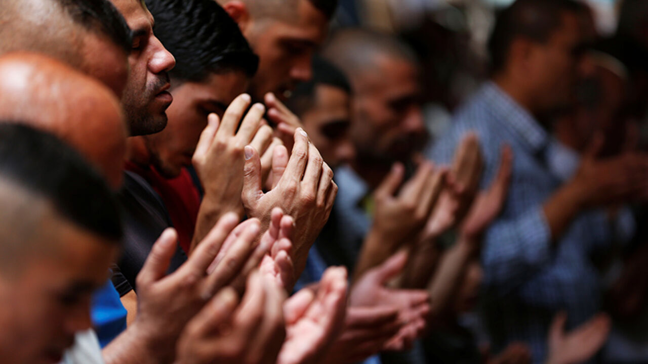 ISRAEL-PALESTINIANS/ Palestinian men pray outside the compound known to Muslims as Noble Sanctuary and to Jews as Temple Mount, in Jerusalem's Old City July 26, 2017. REUTERS/Ronen Zvulun - RTX3CYQ1