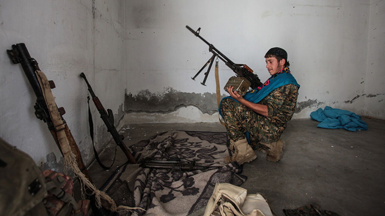 85891374 TAL ABYAD, SYRIA - JUNE 19: (TURKEY OUT) A Kurdish People's Protection Units, or YPG fighter controls the weapons in downtown of Tal Abyad, Syria. June 19, 2015. Kurdish fighters with the YPG took full control of Tal Abyad, dealing a major blow to the Islamic State group's ability to wage war in Syria. Mopping up operations have started to make the town safe for the return of residents from Turkey, after more than a year of Islamic State militants holding control of the town. (Photo by Ahmet Sik/Getty Image