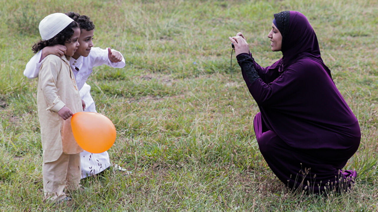 AFP_PX2ON An Egyptian Muslim woman takes a picture of children at the end of prayers on the first day of Eid al-Fitr holiday that marks the end of the holy fasting month of Ramadan on June 25, 2017, in Cairo. / AFP PHOTO / SAMER ABDULLAH (Photo credit should read SAMER ABDULLAH/AFP/Getty Images)