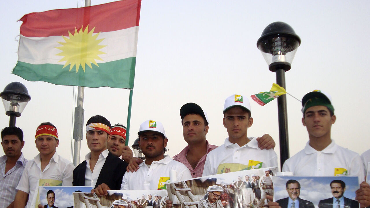 IRAQ/KURDISTAN Supporters of the Patriotic Union of Kurdistan (PUK) hold and wave political posters and flags in Sulaimaniya, 260 km (160 miles) northeast of Baghdad July 9, 2009. Iraqi Kurds going to the polls this month are losing interest in age-old battles with Baghdad over land or oil, and starting to care more about corruption plaguing their largely autonomous northern region. Picture taken July 9, 2009. REUTERS/Tim Cokcs (IRAQ POLITICS ELECTIONS CONFLICT) - GM1E57E1QWK01