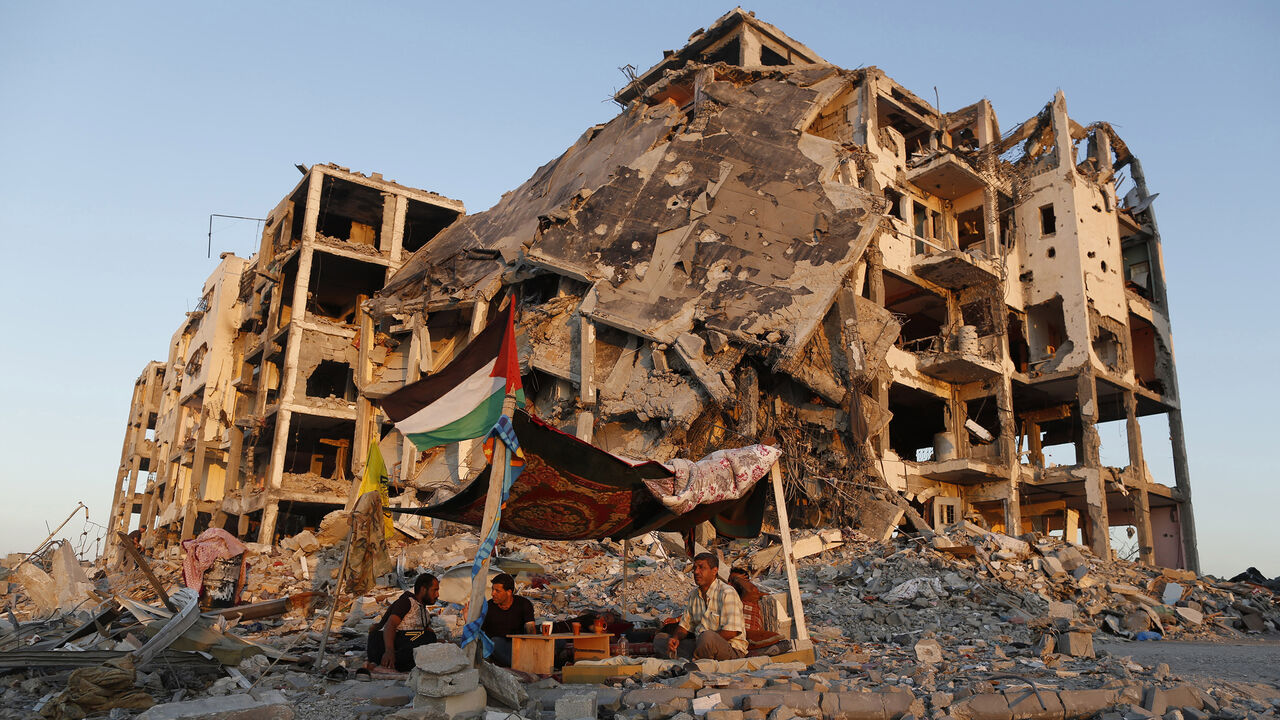 MIDEAST-GAZA/ Palestinians sit in a tent outside their apartments, which witnesses said were destroyed in an Israeli offensive, during a 72-hour truce in Beit Lahiya town in the northern Gaza Strip August 11, 2014. Israeli and Palestinian negotiators resumed indirect talks mediated by Egypt on Monday on ending a month-old Gaza war, Egypt's state news agency said, after a new 72-hour truce appeared to be holding. REUTERS/Suhaib Salem (GAZA - Tags: POLITICS CIVIL UNREST) - RTR4214M