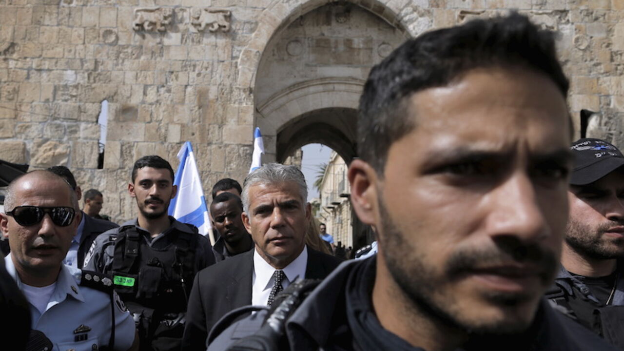 ISRAEL-PALESTINIANS/VIOLENCE Yair Lapid (C), leader of the centrist Yesh Atid party, is surrounded by police as he visits the scene of what Israeli police said was a stabbing attack outside the Lion's Gate of Jerusalem's Old City October 12, 2015. A border policeman shot dead a Palestinian who police said tried to stab him, according to Israeli police. The account was disputed by a Palestinian passerby, who said he witnessed the incident and saw no knife. REUTERS/Ammar Awad - RTS449S