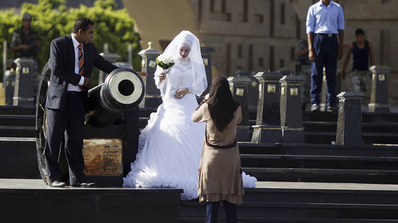 EGYPT-PROTESTS/ A bride and groom have their photos taken in front of the tomb of late Egyptian President Anwar al-Sadat and the Unknown Soldier monument, near a pro-Mursi protest camp in Rabaa Adawiya Square in Nasr City, east of Cairo August 11, 2013. REUTERS/Amr Abdallah Dalsh (EGYPT - Tags: POLITICS SOCIETY) - RTX12HG5