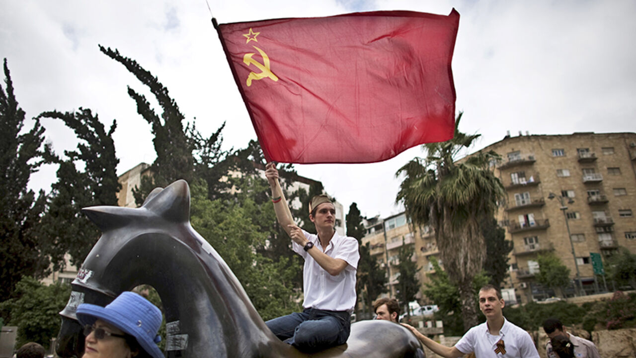 WW2-ANNIVERSARY/ An Israeli waves a Soviet flag during a march in Jerusalem commemorating the 70th anniversary of VE (Victory in Europe) Day May 10, 2015. REUTERS/Ronen Zvulun - RTX1CBAH