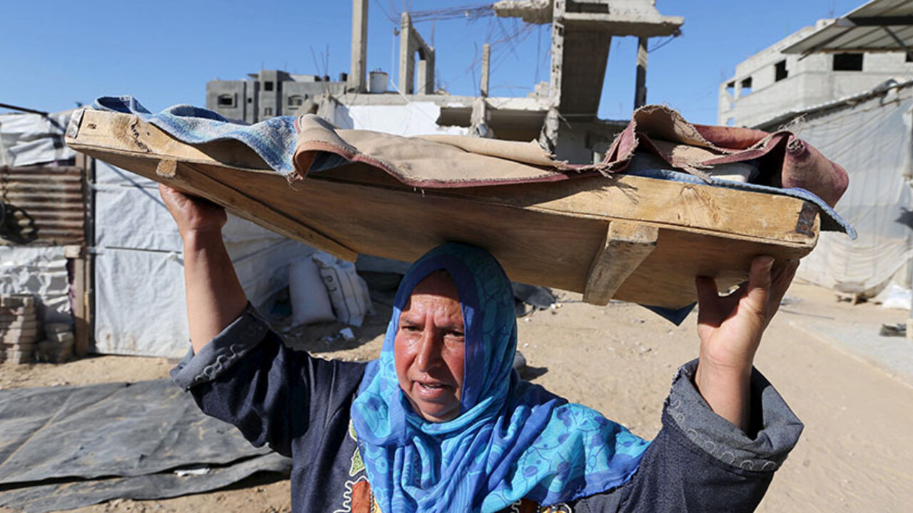 ISRAEL-PALESTINIANS-UN-REACTION/ A Palestinian woman carries bread to be baked, near the wreckage of her house that witnesses said was destroyed by Israeli shelling during a 50-day war last summer, in Khan Younis in the southern Gaza Strip June 22, 2015. Israel disputed on Monday the findings of a U.N. report that it may have committed war crimes in the 2014 Gaza conflict, saying its forces acted "according to the highest international standards". There was no immediate comment from Hamas, the dominant Palestinian movement in the Gaza Stri