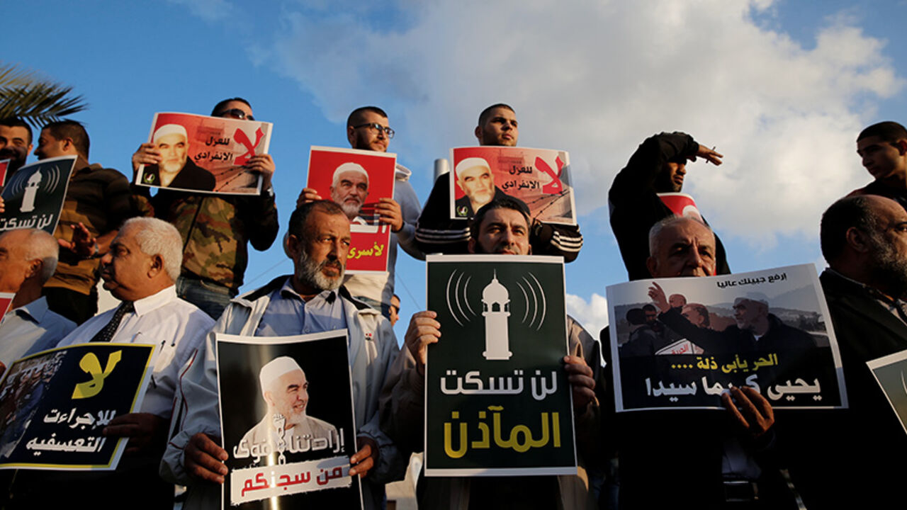 ISRAEL-PALESTINIANS/ Supporters of Sheikh Raed Salah, head of Islamic Movement's northern branch, protest in the Israeli-Arab town of Umm el-Fahm against the initial approval of a bill to enforce lowering the volume of mosque loudspeakers calling worshippers to prayer, November 17, 2016. The placards reads " The mosque's call to prayer will not be silenced" REUTERS/Ammar Awad - RTX2U4XL