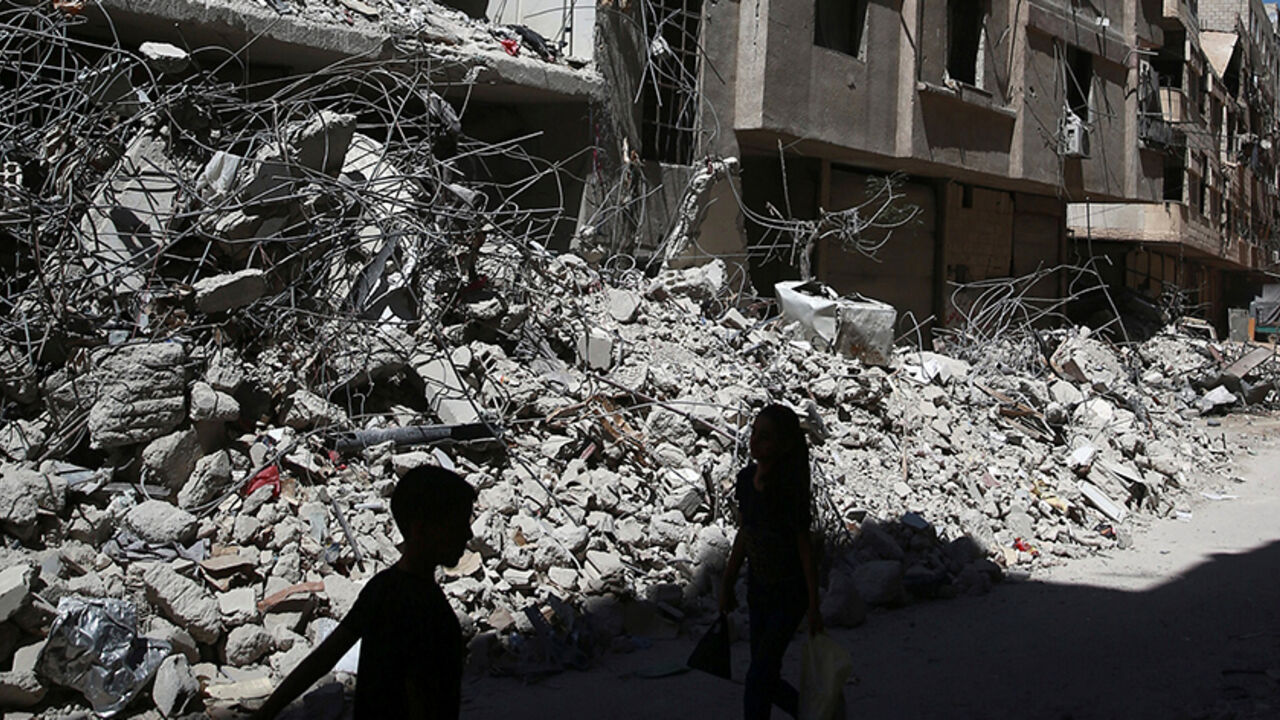 MIDEAST-CRISIS/SYRIA Children walk past rubble of damaged buildings at Ain Tarma, eastern Damascus suburb of Ghouta, Syria July 19, 2017. REUTERS/Bassam Khabieh - RTX3C32C