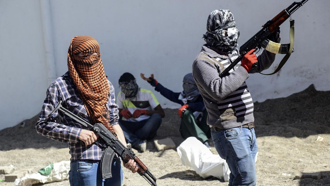 Armed Kurdish militants of the Kurdistan Workers' Party (PKK) stand behind a barricade during clashes with Turkish forces on September 28, 2015, at Bismil, in Diyarbakir. Ankara launched a major "anti-terrorist" campaign against the PKK in late July, aimed at flushing it out of its strongholds in southeastern Turkey and northern Iraq. AFP PHOTO / ILYAS AKENGIN (Photo credit should read ILYAS AKENGIN/AFP/Getty Images)
