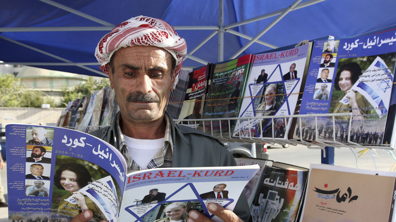 A man reads a copy of the magazine "Israel-Kurd" at a street in Arbil, 310 km (190 miles) north of Baghdad August 16, 2009. REUTERS/Azad Lashkari (IRAQ SOCIETY) - GM1E58H06K201