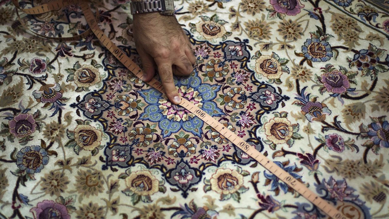 IRAN/ EDITORS' NOTE: Reuters and other foreign media are subject to Iranian restrictions on leaving the office to report, film or take pictures in Tehran.
Artin Markosian, professor at Isfahan's Art University, measures a carpet during his visit to Iran's Persian handmade carpet fair in Isfahan, 450 km (280 miles) south of Tehran, November 14, 2011. Persian carpet weaving is a historical part of Iranian culture, dating back to as far as approximately 2,000 years ago. Persian carpets can be mostly divided into th