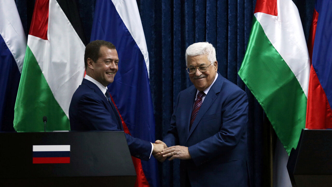 PALESTINIANS-RUSSIA/ Russia's Prime Minister Dmitry Medvedev (L) shakes hands with Palestinian President Mahmoud Abbas after a joint news conference in the West Bank city of Jericho November 11, 2016. REUTERS/Mohamad Torokman - S1AEUMFKOAAB