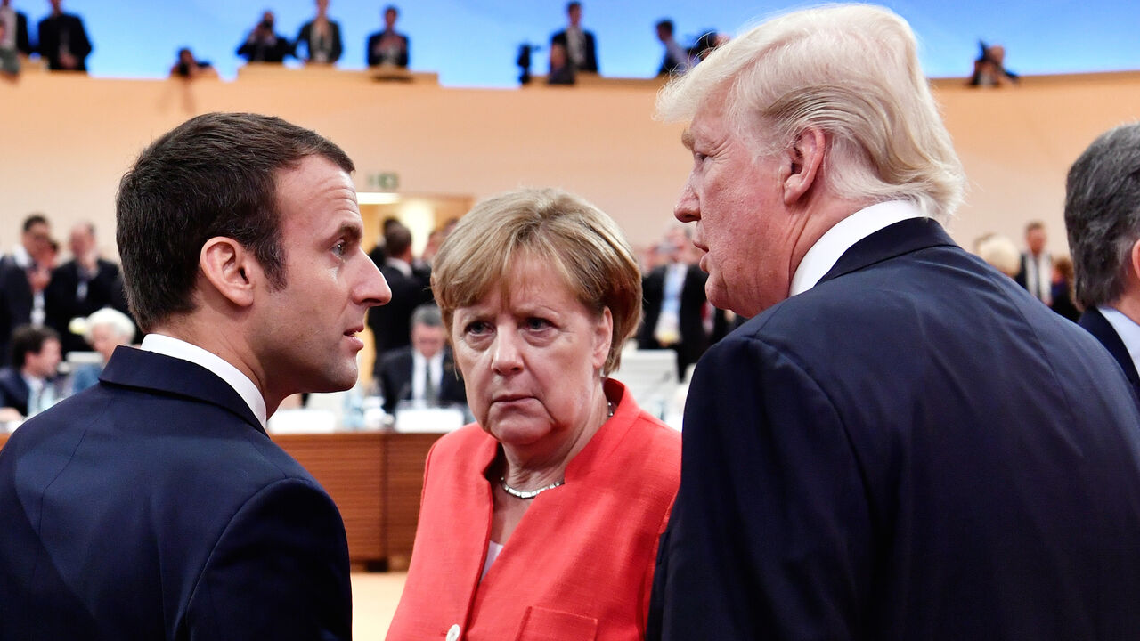 G20-GERMANY/ French President Emmanuel Macron, German Chancellor Angela Merkel and U.S. President Donald Trump confer s Argentinia's President Mauricio Macri walks past them at the start of the first working session of the G20 meeting in Hamburg, Germany, July 7, 2017. REUTERS/John MacDougall/Pool - RC18A478F480