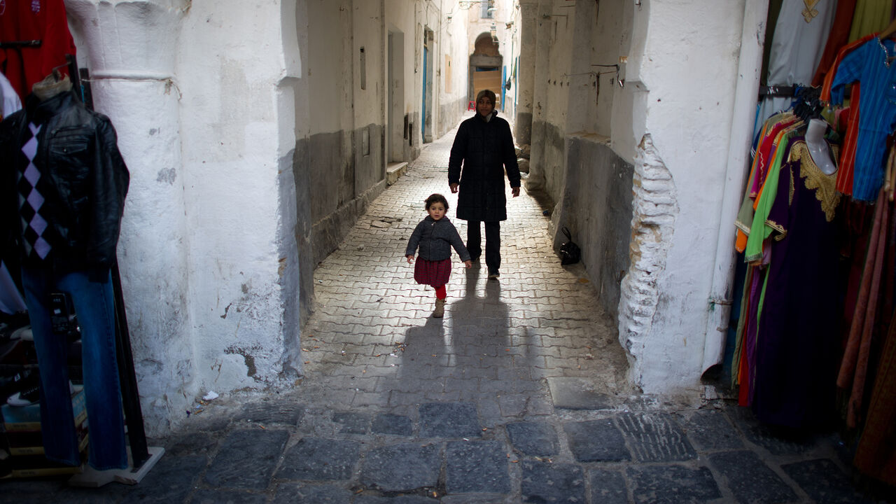Par3730597 A mother and her child walk in a street of "La Medina" in cental Tunis on January 21, 2011. Tunisia began national mourning Friday for the dozens killed in its revolution, a week after the ouster of veteran ruler Zine El Abidine Ben Ali, as new protests called for the old regime to be destroyed. AFP PHOTO / MARTIN BUREAU (Photo credit should read MARTIN BUREAU/AFP/Getty Images)