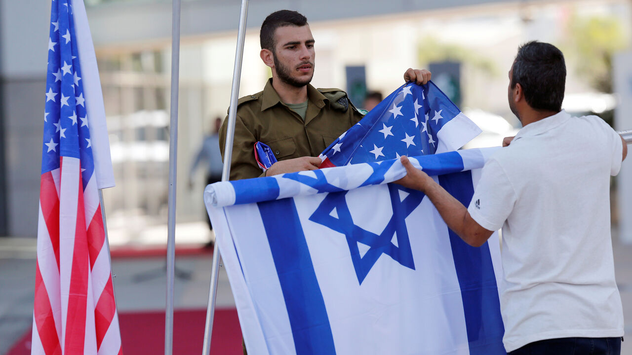 ISRAEL-USA/MILITARY An Israeli soldier (L) helps to roll up the Israeli and American flags after an honor guard ceremony held for General Joseph Dunford, the Chairman of the U.S. Joint Chiefs of Staff, in Tel Aviv, Israel May 9, 2017. REUTERS/Nir Elias - RC157C6035A0