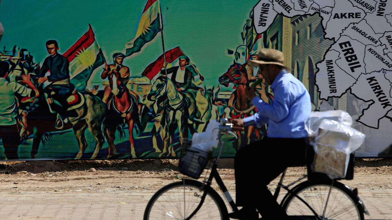 MIDEAST-CRISIS/KURDS-REFERENDUM A man rides a bike near a mural supporting the referendum for independence of Kurdistan in Erbil, Iraq September 24, 2017. REUTERS/Alaa Al-Marjani TPX IMAGES OF THE DAY - RC12B8261980
