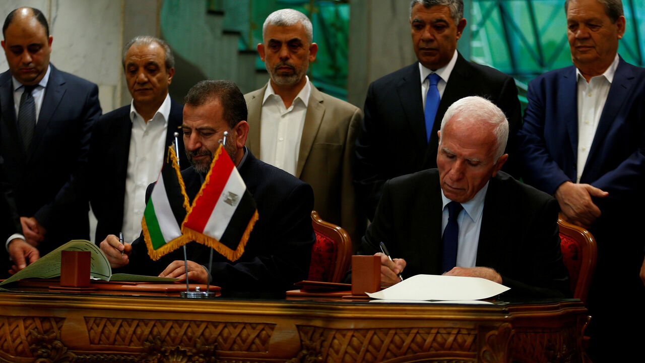 PALESTINIANS-TALKS/ Head of Hamas delegation Saleh Arouri and Fatah leader Azzam Ahmad sign a reconciliation deal in Cairo, Egypt, October 12, 2017. REUTERS/Amr Abdallah Dalsh TPX IMAGES OF THE DAY - RC12E7E090C0