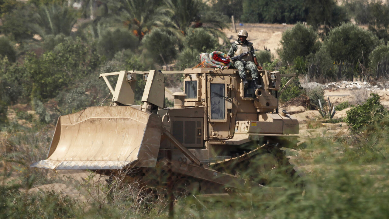 PALESTINIANS-EGYPT/GAZA An Egyptian soldier sits atop a bulldozer on the border between Egypt and southern Gaza Strip September 12, 2013. Cairo closed the Rafah crossing, Gaza's main window to the world, completely on Wednesday after assailants crashed two explosive-laden cars into a security building adjacent to the border zone, killing six Egyptian soldiers. The bulldozing of the tunnels has deepened Gaza residents' feelings of isolation in a tiny coastal territory that many have described as a prison. Egypt has suggested Palest