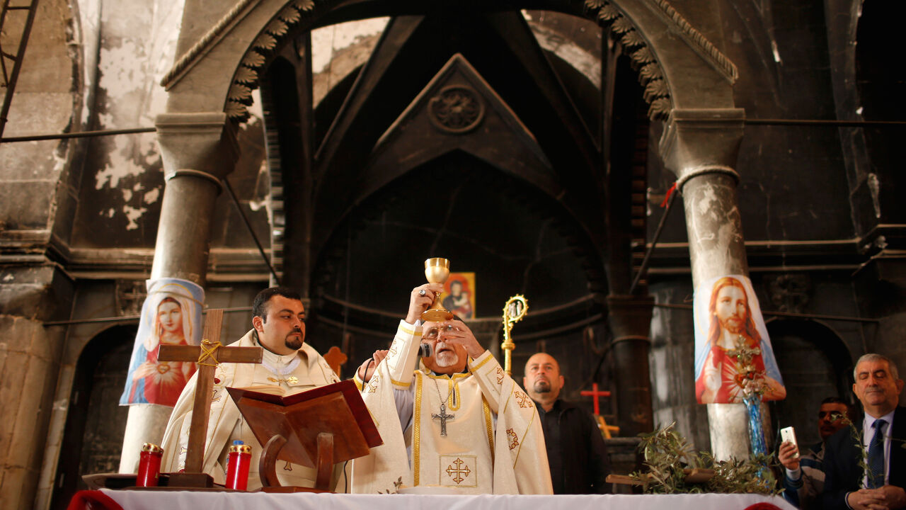 MIDEAST-CRISIS/IRAQ-MOSUL-CHRISTIANS Iraqis attend the first Palm Sunday procession in the burnt out main church of the Christian city of Qaraqosh since Iraqi forces retook it from Islamic States militants, Iraq April 9, 2017. REUTERS/Suhaib Salem - RC1AB7BBA420