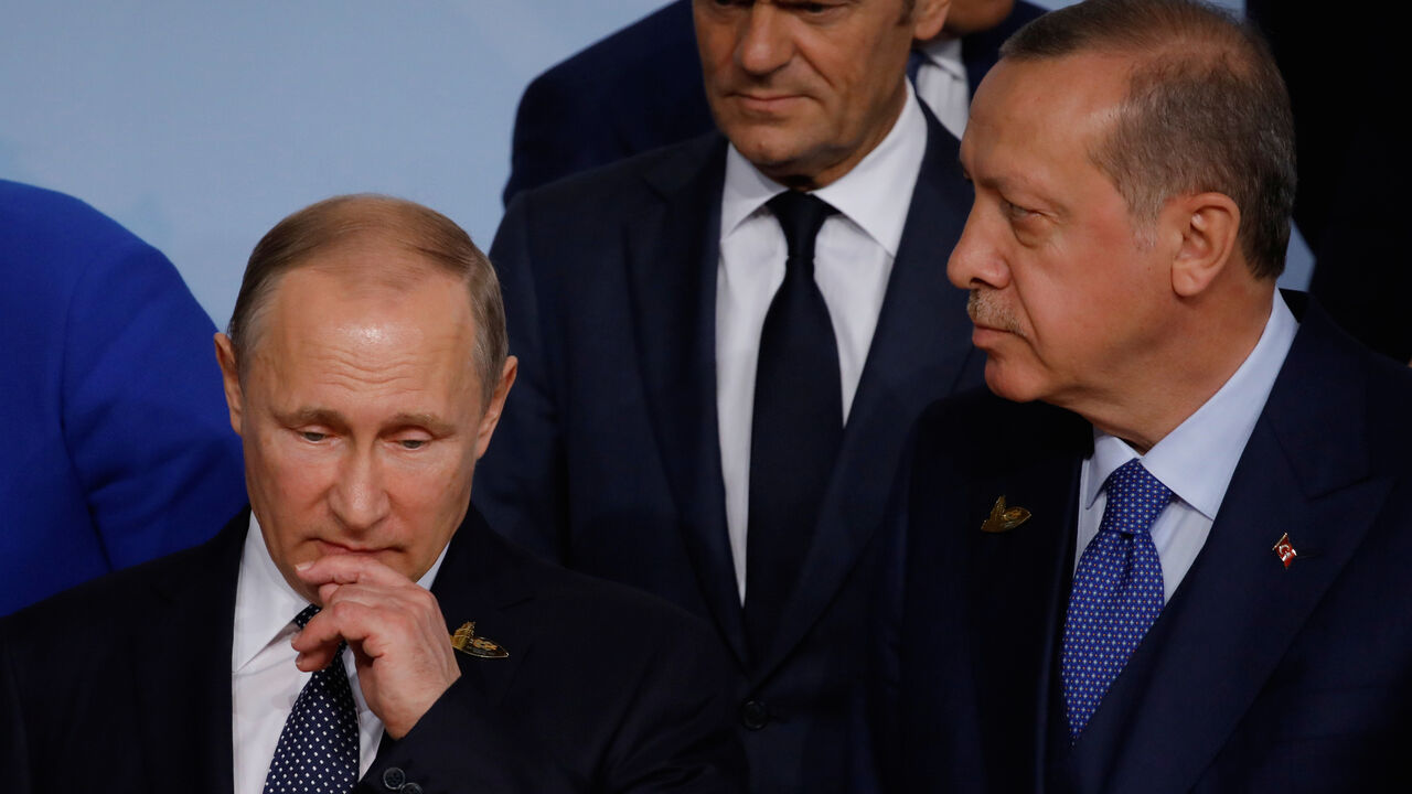 G20-GERMANY/ Russian President Vladimir Putin looks on next to European Council President Donald Tusk and Turkish President Recep Tayyip Erdogan at the G20 summit in Hamburg, Germany July 7, 2017. REUTERS/Carlos Barria - RC1D608EC340
