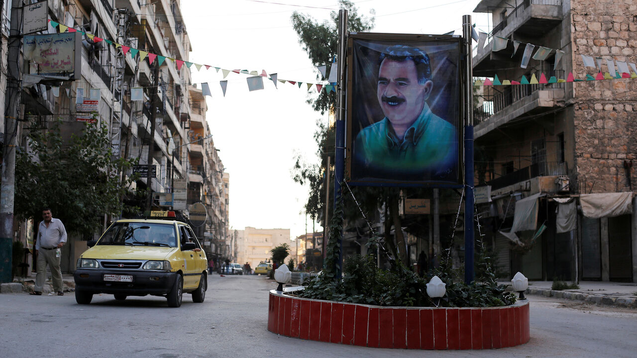 MIDEAST-CRISIS/ALEPPO-KURDS A car passes by a picture of the Kurdish leader Abdullah Ocalan of the Kurdistan Workers Party (PKK) in Aleppo's Sheikh Maqsoud neighbourhood, Syria July 15, 2017. Picture taken July 15, 2017. REUTERS/Omar Sanadiki - RC1F9BDFCDB0