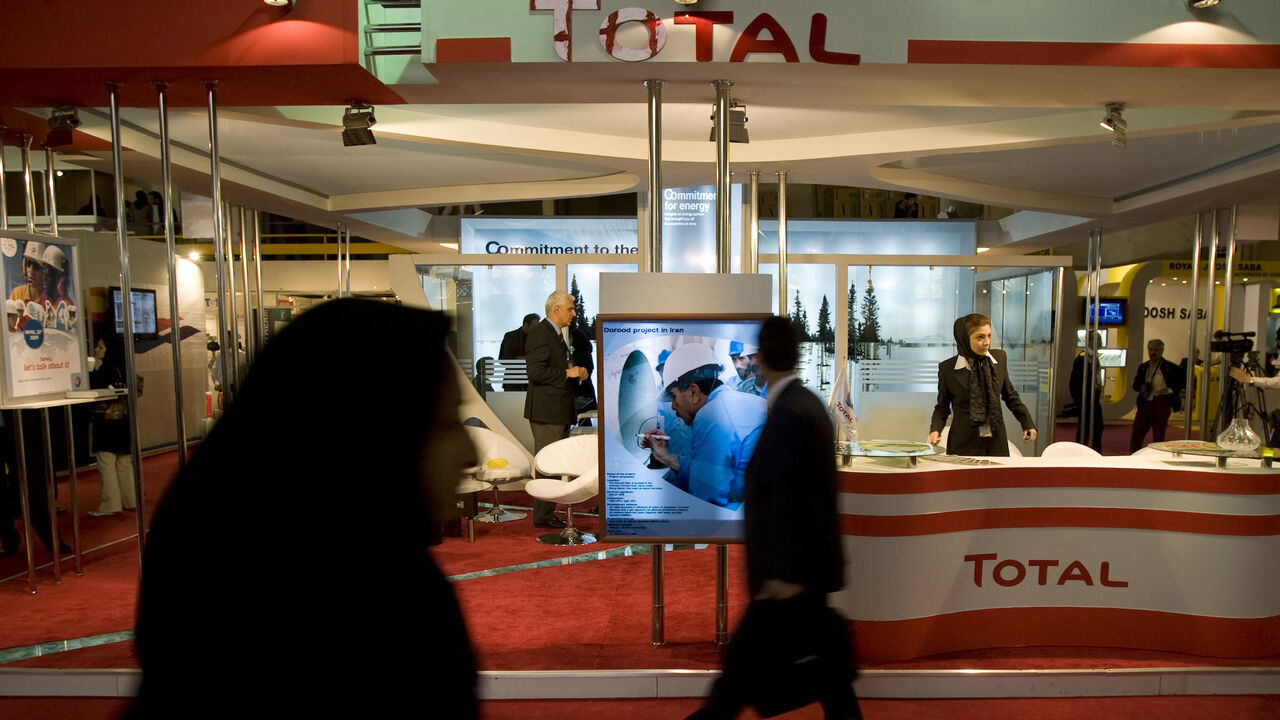 IRAN-OPEC/ Visitors walk past Total's stand at the 14th International Oil, Gas & Petrochemical Exhibition (IOGPE) in Tehran April 21, 2009. REUTERS/Morteza Nikoubazl (IRAN BUSINESS ENERGY) - GM1E54L1IS801
