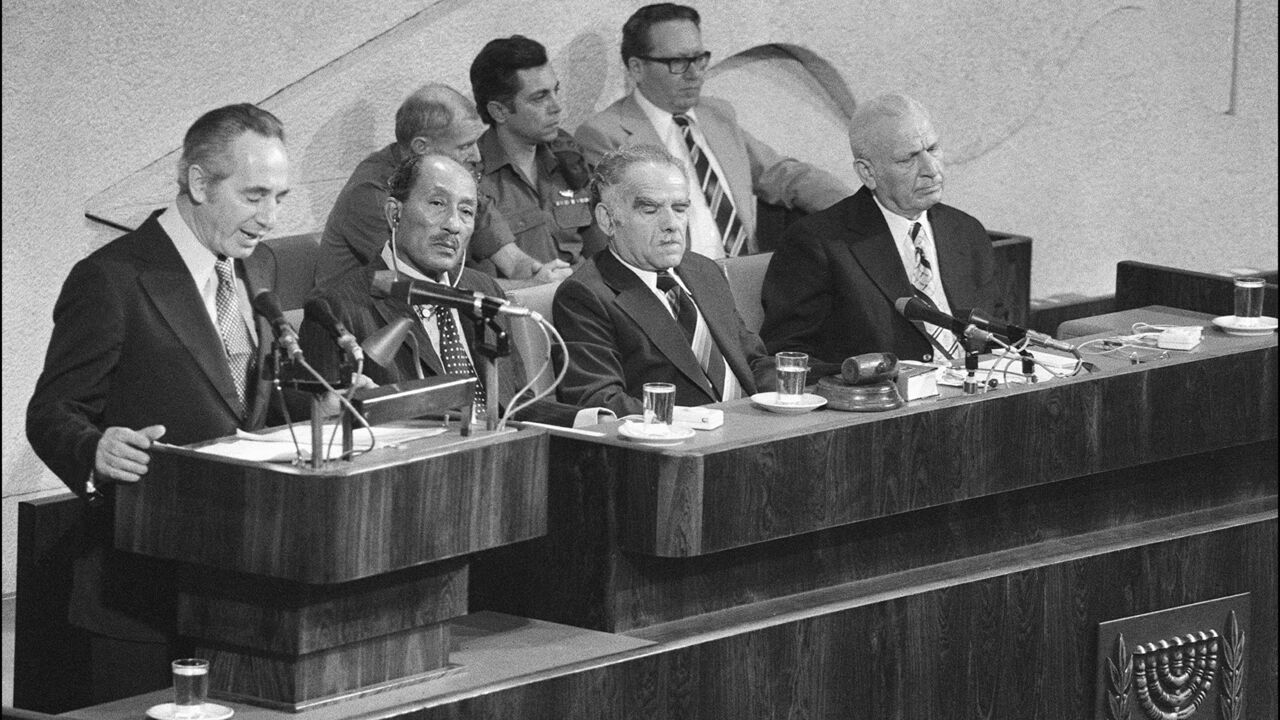 SAPA980414402150 (FILES) Israeli Labor party leader Shimon Peres (l) addresses 20 November 1977 in Jerusalem the Knesset (parliament) as Egyptian President Anwar al-Sadat (c) and Israeli Foreign minister Yitzhak Shamir (2nd-r) listen during Egypt's President historic visit to Israel. Talks between Sadat and Begin continued and after various delays an unexpected breakthrough occurred in September 1978 after talks at Camp David in the USA under the guidance of US President Carter, when Begin and Sadat signed two peace agreeme