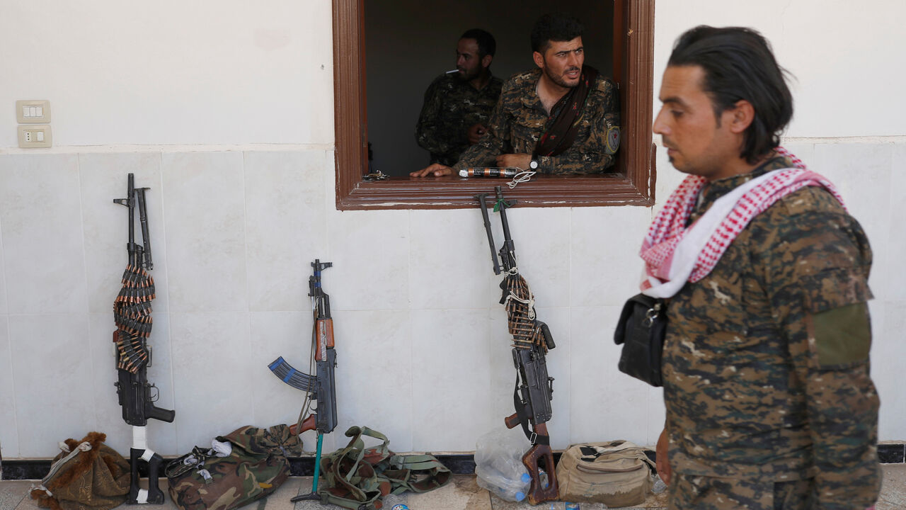 MIDEAST-CRISIS/SYRIA-RAQQA A Kurdish fighter from the People's Protection Units (YPG) looks out of a window in Raqqa, Syria June 18, 2017. REUTERS/Goran Tomasevic TPX IMAGES OF THE DAY - RC14F5DB6150