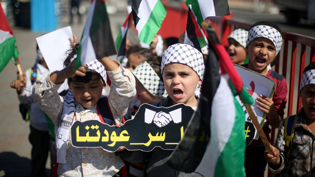 PALESTINIANS-RECONCILIATION/MOOD Children hold Palestinian flags as they celebrate after rival Palestinian factions Hamas and Fatah signed a reconciliation deal, in the central Gaza Strip October 12, 2017. Picture taken October 12, 2017. REUTERS/Ibraheem Abu Mustafa - RC17AA0B40E0