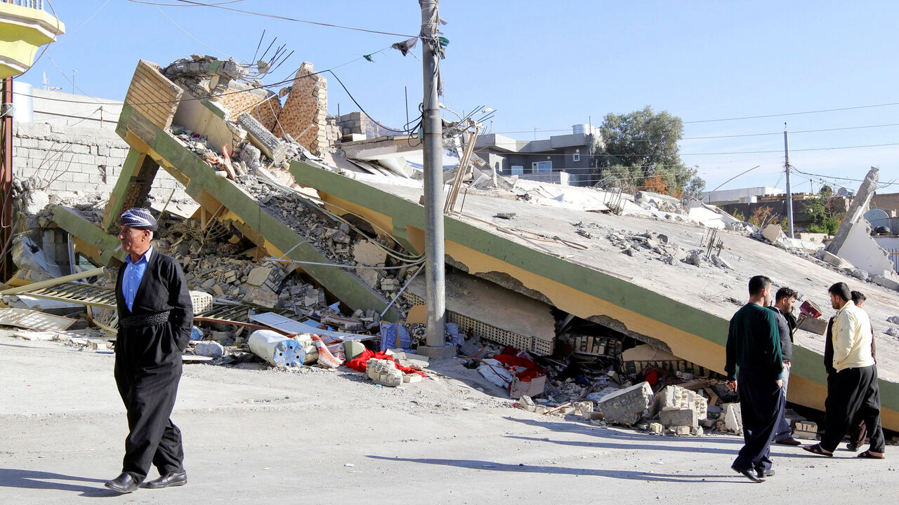 IRAQ-QUAKE/IRAN People walk past a damaged building following an earthquake in the town of Darbandikhan, near the city of Sulaimaniyah, in the semi-autonomous Kurdistan region, Iraq November 13, 2017. REUTERS/Ako Rasheed - RC1AE3732600