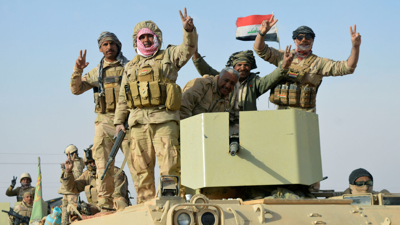 MIDEAST-CRISIS/IRAQ-ISLAMIC-STATE Iraqi forces show victory signs after they captured Rawa town, the last remaining town under Islamic State control, Iraq November 17, 2017. REUTERS/Stringer - RC16EFE59700