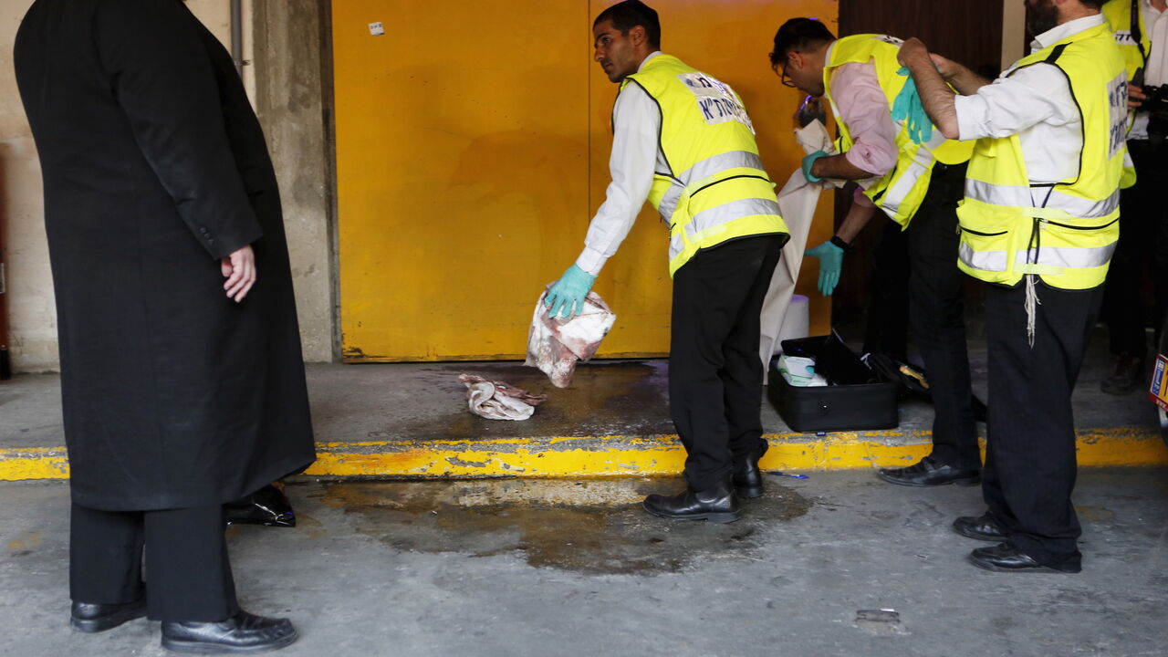 ISRAEL-PALESTINIANS/ Zaka emergency personnel clean a bloodstain from the ground at the scene of a Palestinian stabbing attack in Tel Aviv, Israel November 19, 2015. REUTERS/Nir Elias - GF20000066046
