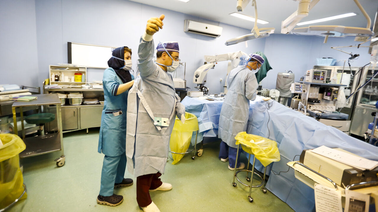 IRAN-HEALTH/ Iranian surgeon Ali Manafi puts on his sterile gown before performing a nose surgery on a female patient in the operating room at a hospital in Tehran August 19, 2015. Iran has the most numbers of rhinoplasty procedures, or nose jobs, done in the world, according to local media.REUTERS/Raheb Homavandi/TIMAATTENTION EDITORS - THIS PICTURE WAS PROVIDED BY A THIRD PARTY. REUTERS IS UNABLE TO INDEPENDENTLY VERIFY THE AUTHENTICITY, CONTENT, LOCATION OR DATE OF THIS IMAGE. FOR EDITORIAL USE ONLY. NOT FOR SALE FO
