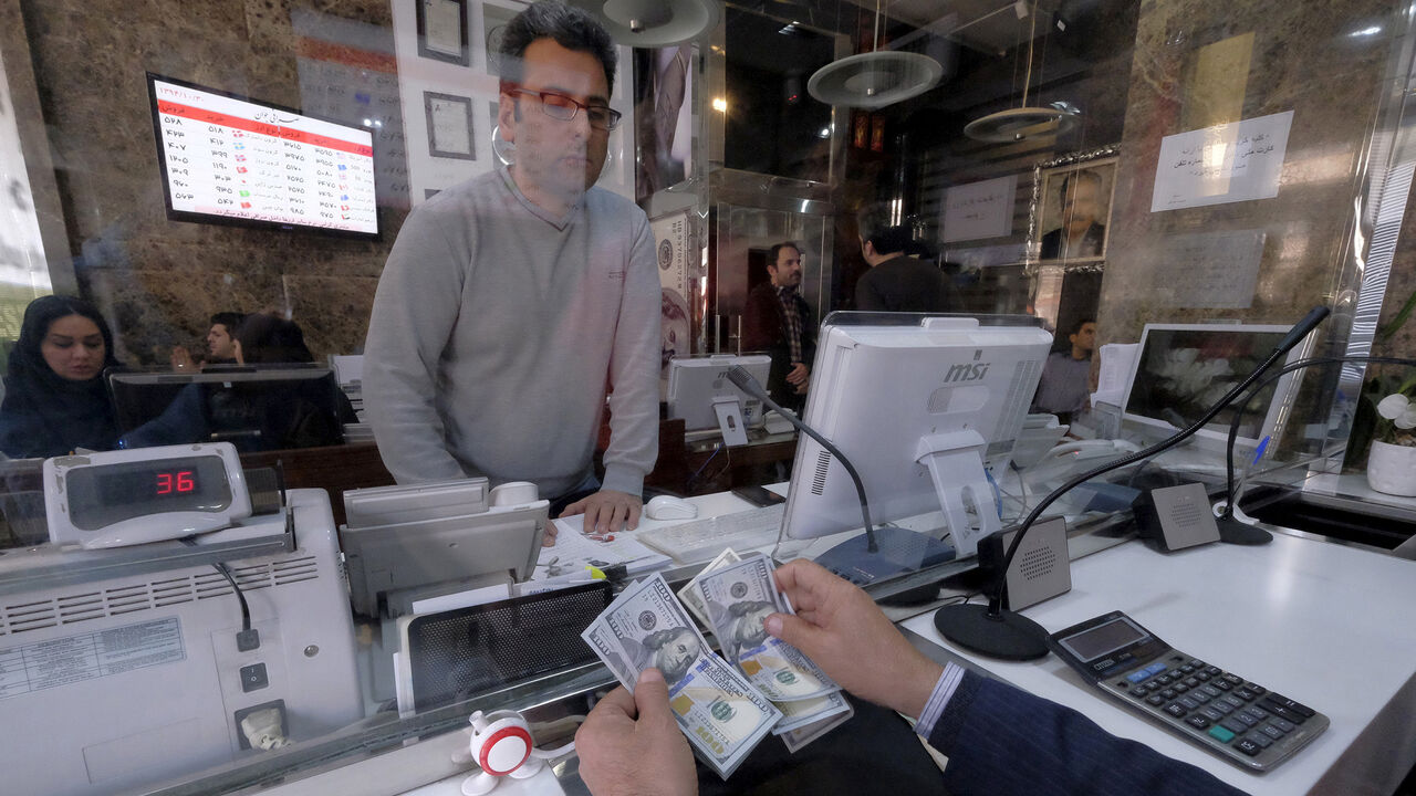 IRAN-NUCLEAR/INVESTMENT A money changer counts out U.S. dollars for a customer in Tehran's business district, Iran, January 20, 2016. REUTERS/Raheb Homavandi/TIMA ATTENTION EDITORS - THIS IMAGE WAS PROVIDED BY A THIRD PARTY. FOR EDITORIAL USE ONLY. - GF20000100973