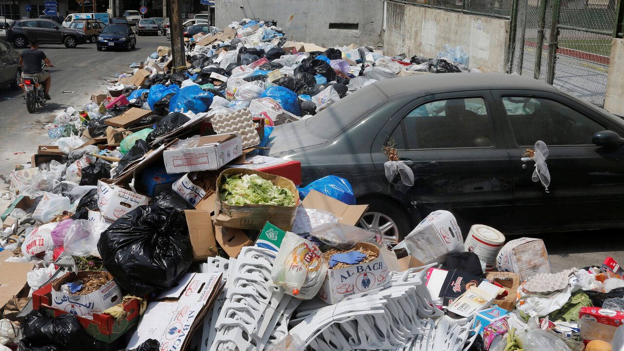 LEBANON-RUBBISH/ A car is blocked by garbage piled up along a street in Dekwaneh area, Mount Lebanon August 29, 2016. REUTERS/Mohamed Azakir - S1AETYGHNHAA
