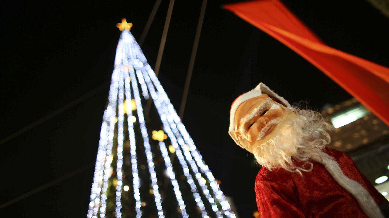 ISRAEL/ A boy wearing a Santa Claus costume attends a Christmas tree lighting ceremony in the northern town of Nazareth, the town of Jesus' boyhood, December 12, 2012. REUTERS/Ammar Awad (ISRAEL - Tags: RELIGION) - GM1E8CD0CSI01