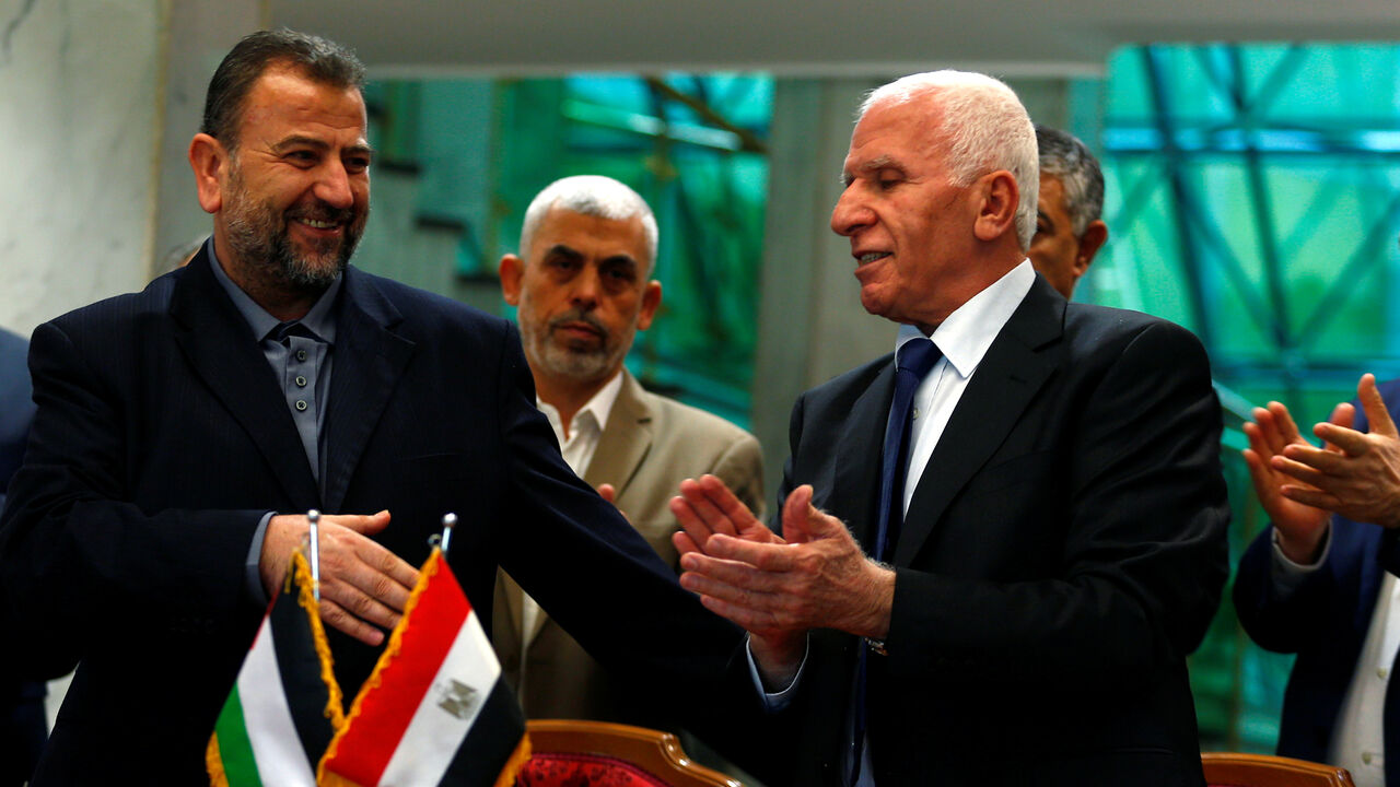 PALESTINIANS-TALKS/ Head of Hamas delegation Saleh Arouri and Fatah leader Azzam Ahmad sign a reconciliation deal in Cairo, Egypt, October 12, 2017. REUTERS/Amr Abdallah Dalsh - RC12DBB41E80