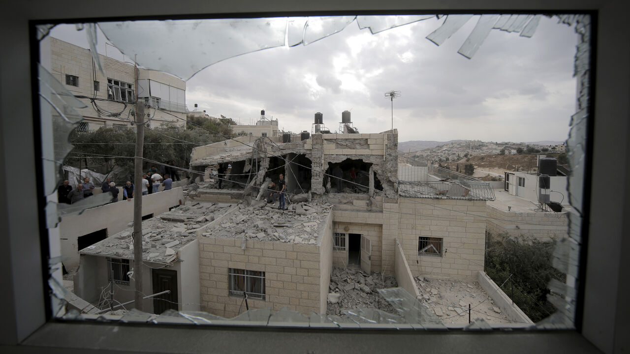 ISRAEL-PALESTINIANS/ Palestinians stand on the razed home of a Palestinian militant in Jabel Mukaber, in an area of the West Bank that Israel captured in a 1967 war and annexed to the city of Jerusalem, October 6, 2015. Israeli forces destroyed the homes of two Palestinian militants and sealed off part of a third in Jerusalem on Tuesday, in a crackdown launched by Prime Minister Benjamin Netanyahu after four Israelis were killed in Palestinian attacks. The Israeli military said in a statement it had demolished the family home o